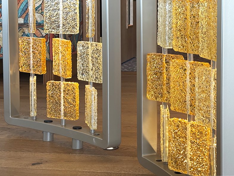 Steel frame and base of the cast glass screens at The BoTree hotel, amber glass tiles catching the light